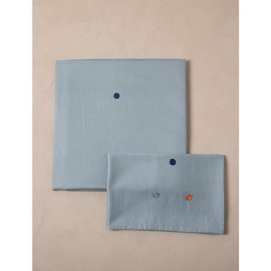 Two light blue napkins with embroidered designs on a beige background