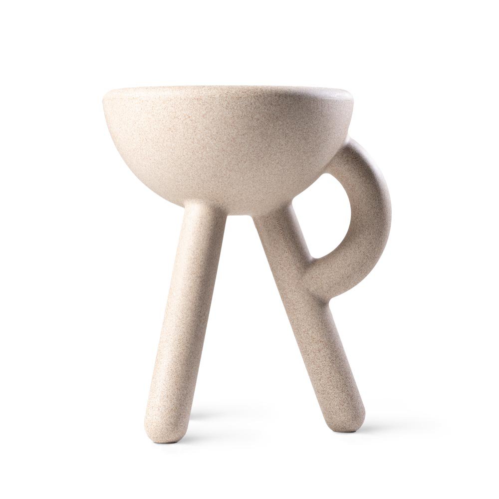 Beige ceramic cup with three legs on a white background