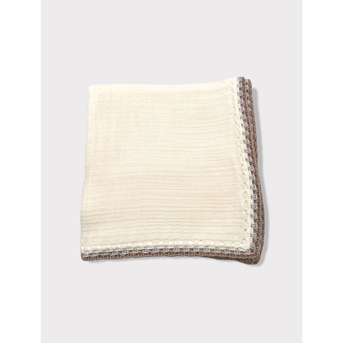 Folded cream-colored blanket on a white background