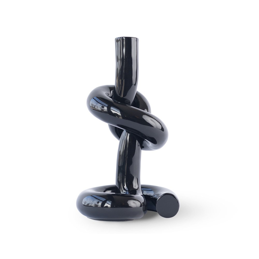 Black knot-shaped candle holder on a white background