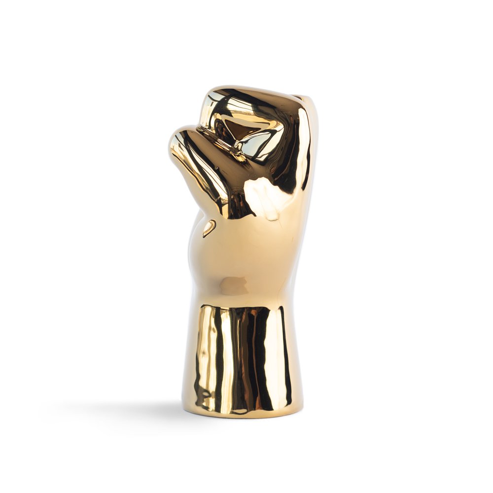 Gold-colored sculpture of a hand on a white background