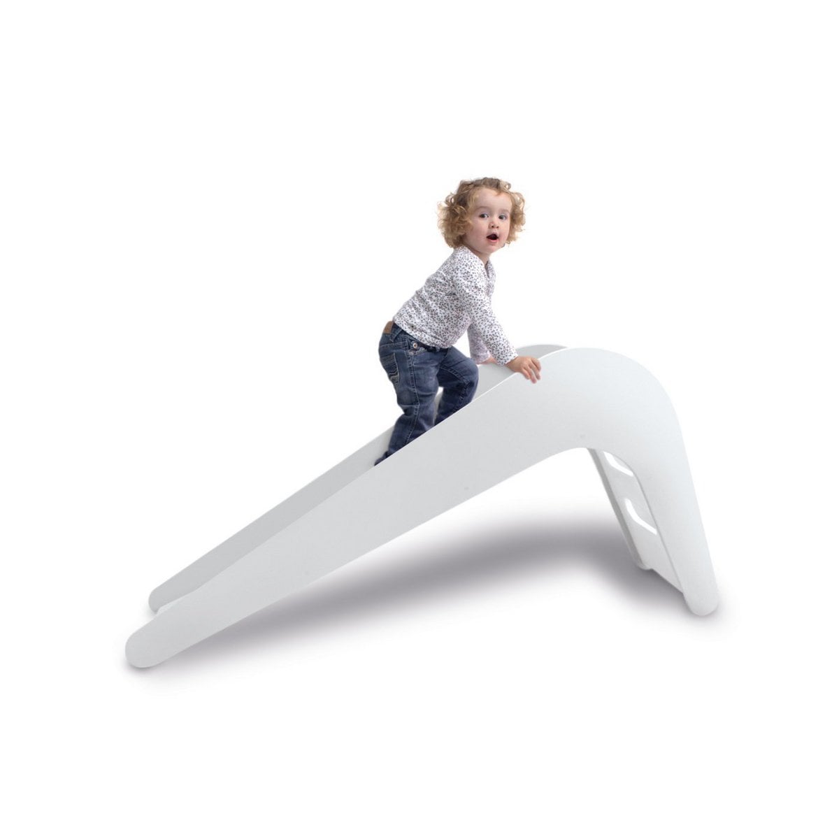 Child playing on a white plastic slide against a white background