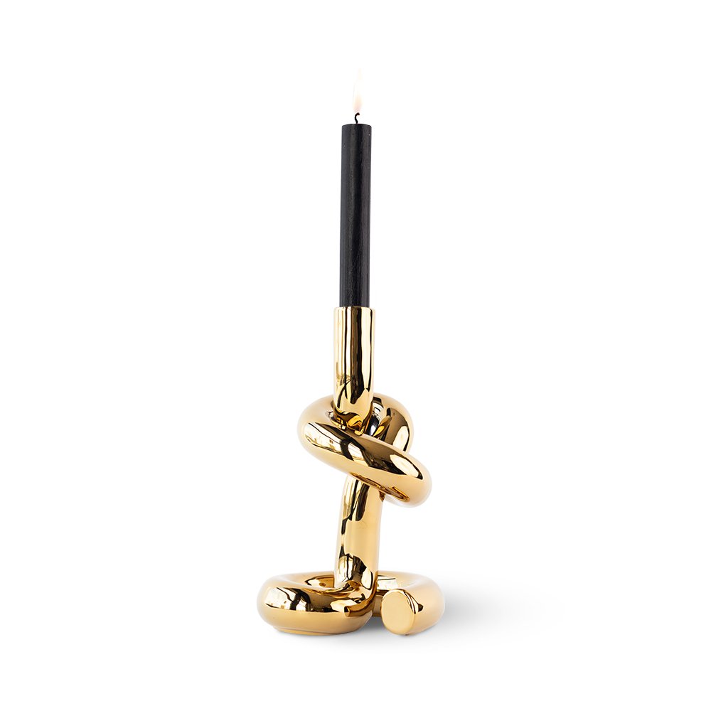 Decorative candle holder with gold knot design on a white background