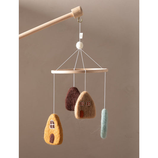 Hanging mobile with felt houses on a wooden stick against a beige background