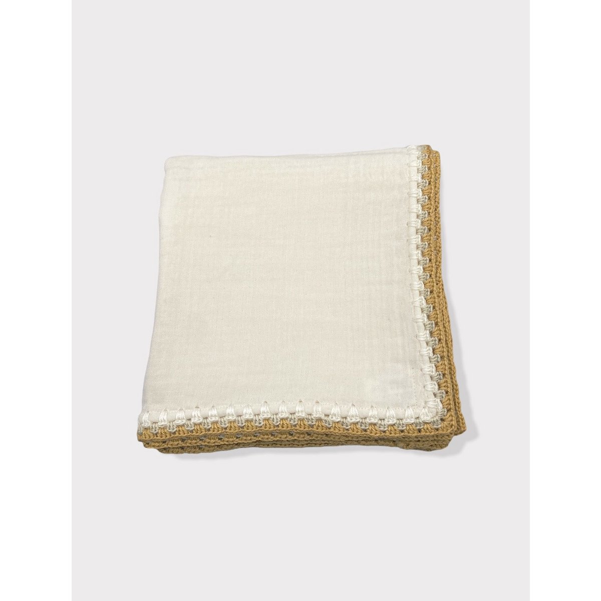 Folded beige blanket with textured border on a white background