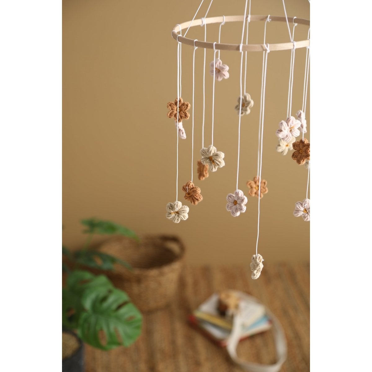 Decorative hanging mobile with flowers against a beige wall