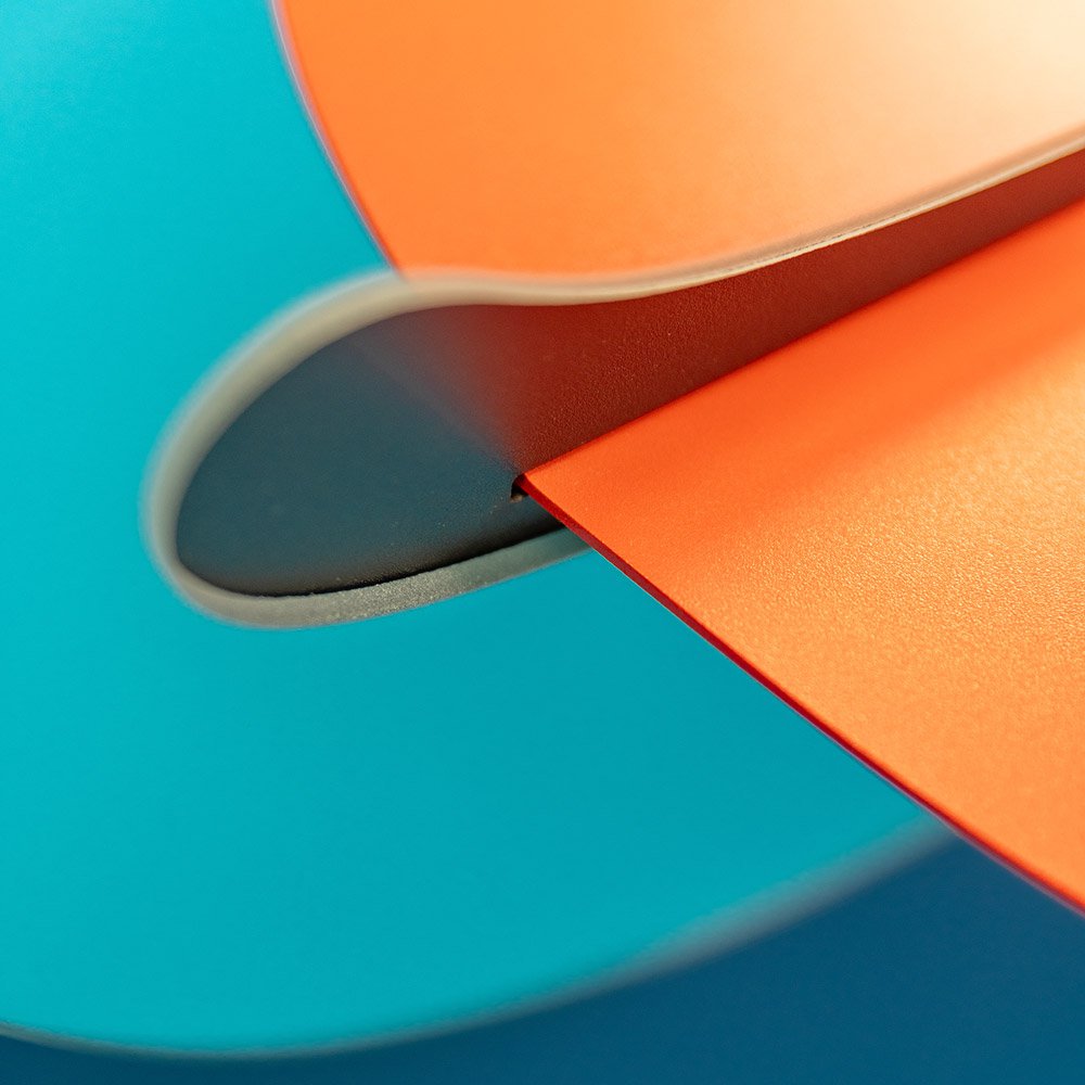 Close-up of orange and blue paper with a crease on a blue background