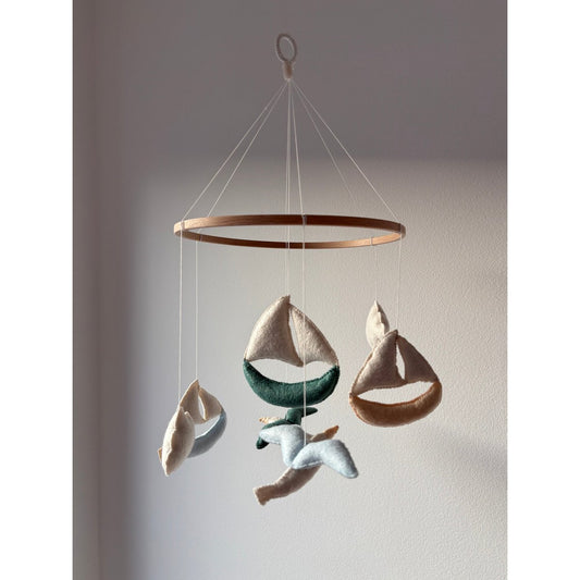 Decorative hanging mobile with sailboats on a plain background