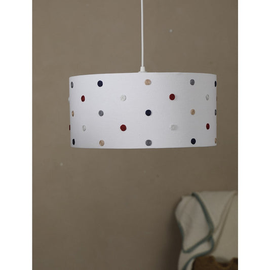 White lampshade with colorful polka dots hanging against a beige wall.