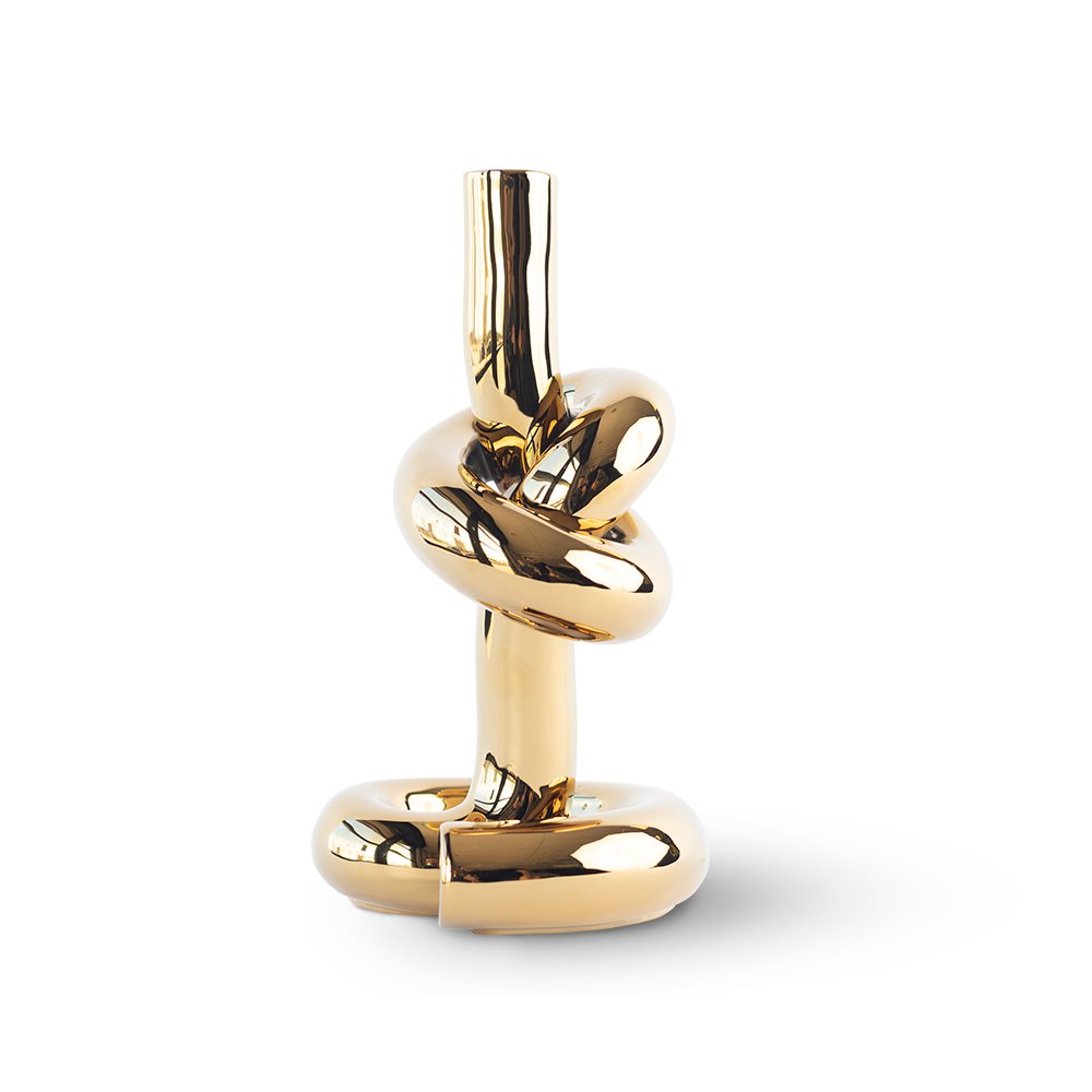 Gold knot-shaped decorative object on a white background