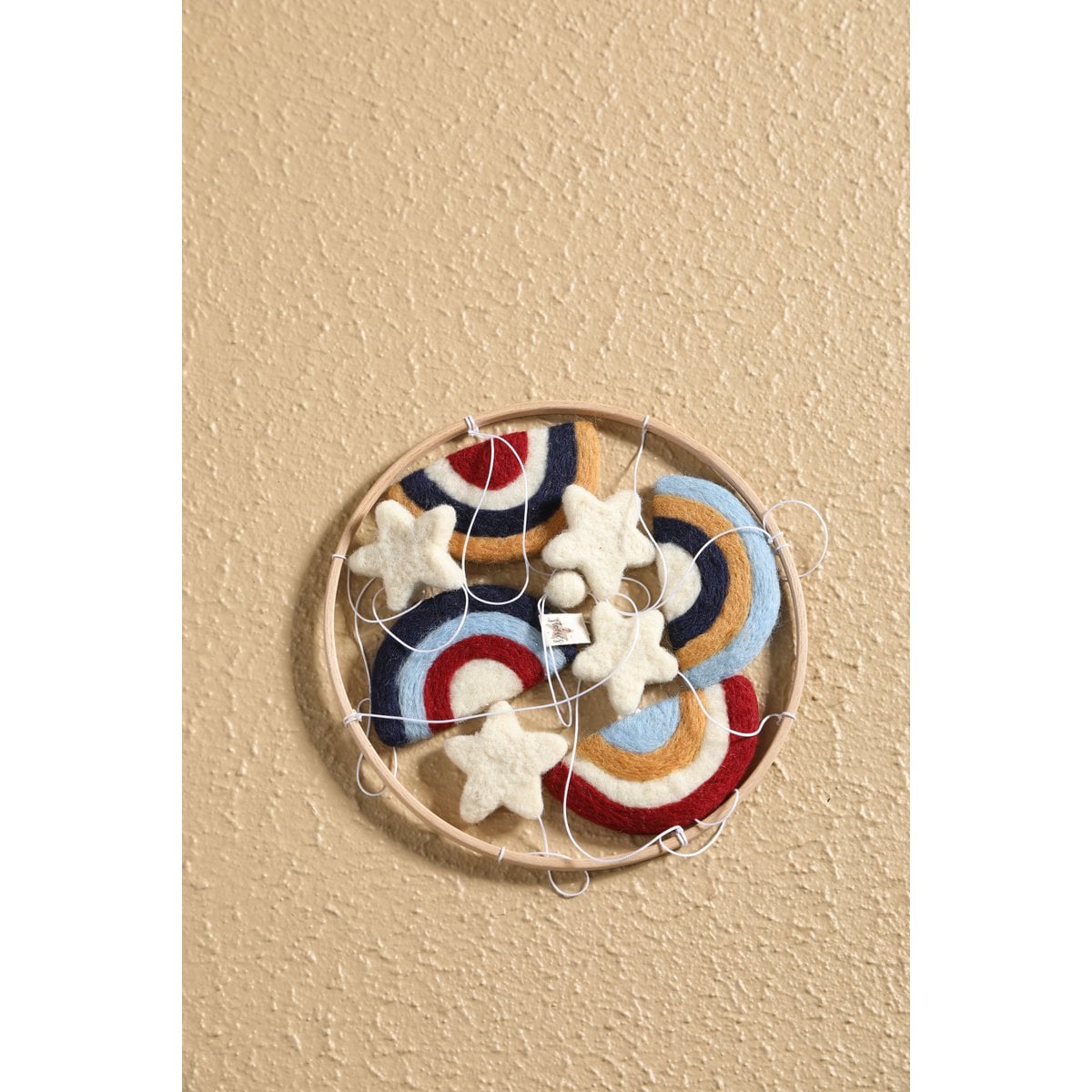 Decorative wall art with colorful stars and arches on a beige background