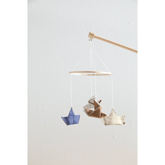 Three paper boats hanging from a string against a light gray background