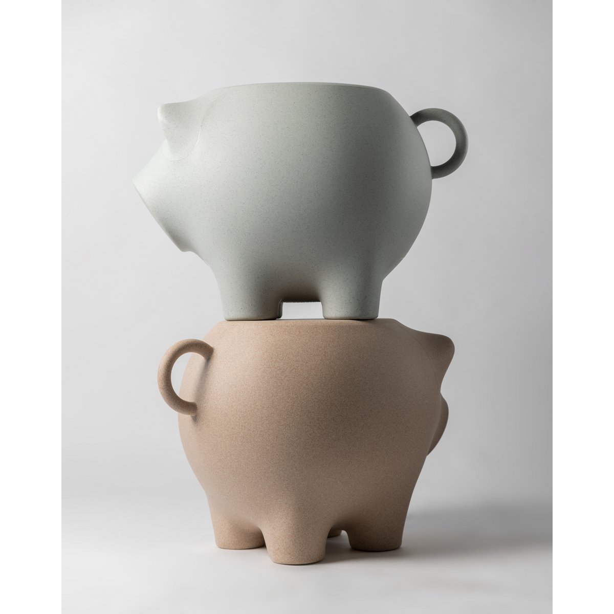 Two ceramic pots stacked on a plain background