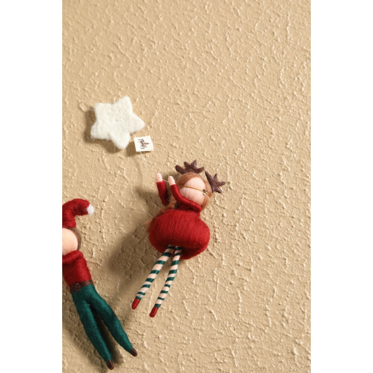 Small decorative elf figurine with a star on a textured beige surface