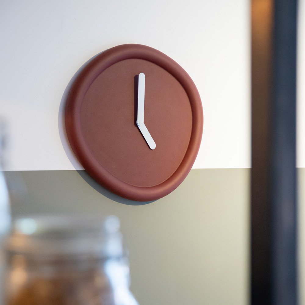 Round brown clock with white hands on a wall
