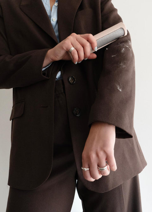 Person wearing a brown suit holding a phone with a white background